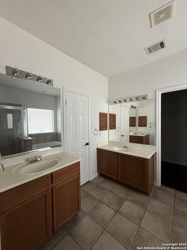 bathroom featuring tile patterned flooring, shower with separate bathtub, and vanity