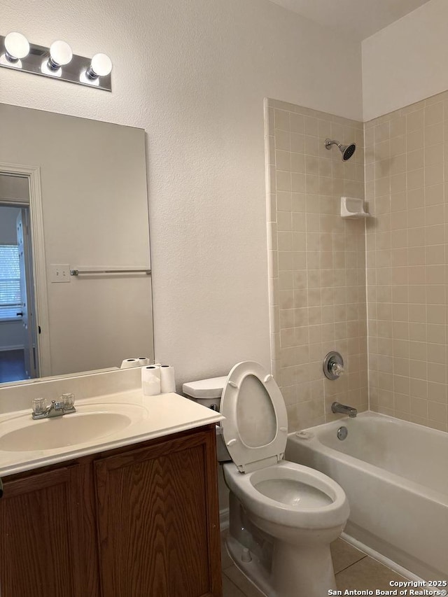 full bathroom featuring toilet, tile patterned floors, vanity, and tiled shower / bath