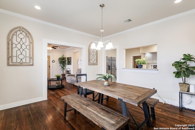 dining area featuring ceiling fan with notable chandelier, dark hardwood / wood-style flooring, and crown molding