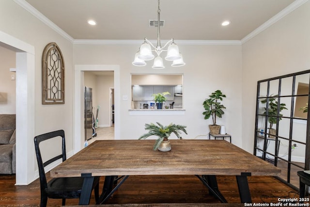 dining area with a chandelier, crown molding, and dark wood-type flooring