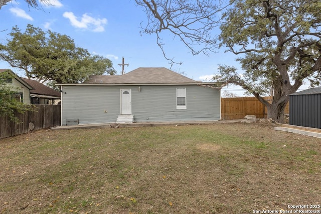 rear view of property featuring a yard