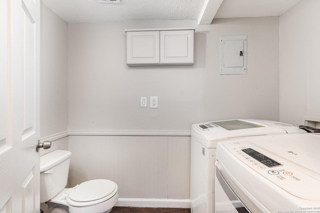 laundry room featuring electric panel, a textured ceiling, and independent washer and dryer