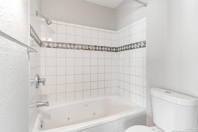 bathroom featuring toilet and tiled shower / bath