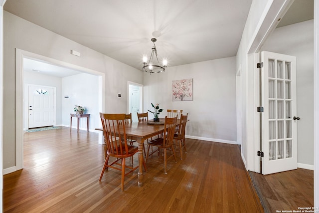 dining space featuring wood-type flooring and a chandelier