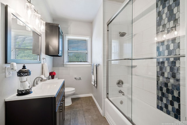 full bathroom with toilet, vanity, and shower / bath combination with glass door