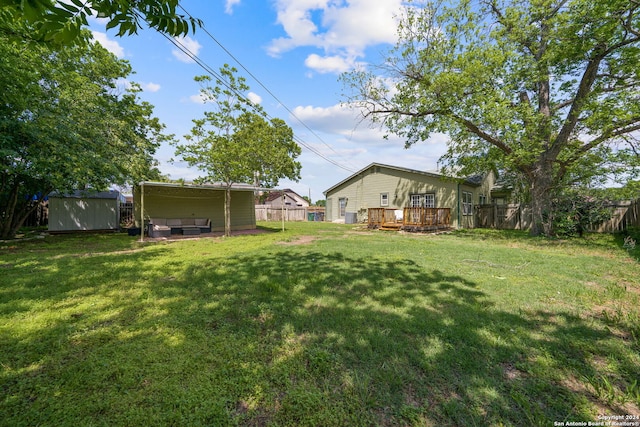 view of yard featuring a deck and a shed