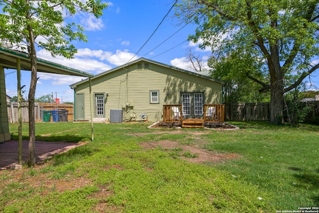 back of house with central AC, a yard, and a deck