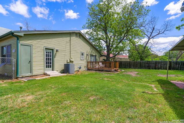 rear view of house featuring central AC unit, a yard, and a deck