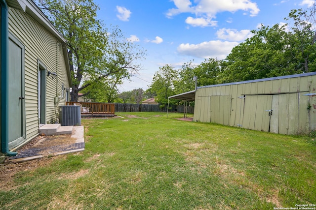 view of yard featuring an outbuilding, a deck, and central air condition unit