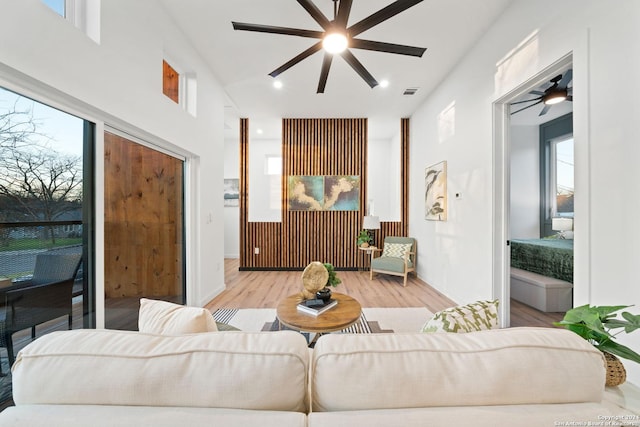 living room featuring light hardwood / wood-style floors, ceiling fan, and a healthy amount of sunlight