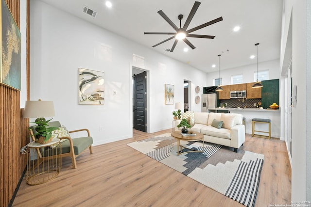 living room featuring light wood-type flooring and ceiling fan