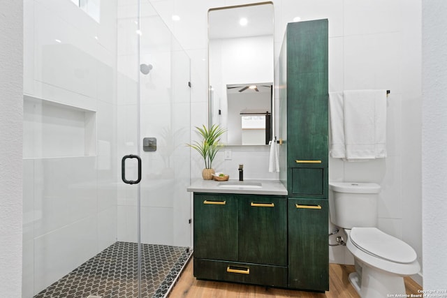 bathroom featuring hardwood / wood-style flooring, toilet, an enclosed shower, and vanity