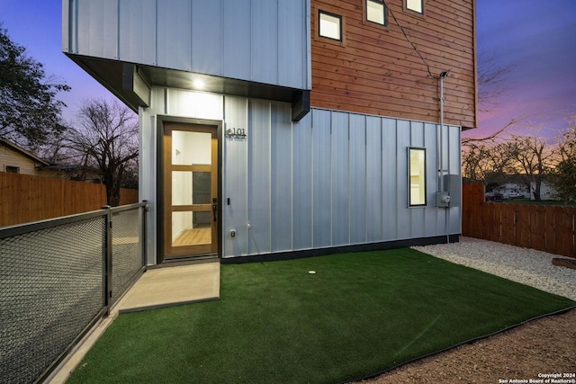 exterior entry at dusk with a lawn