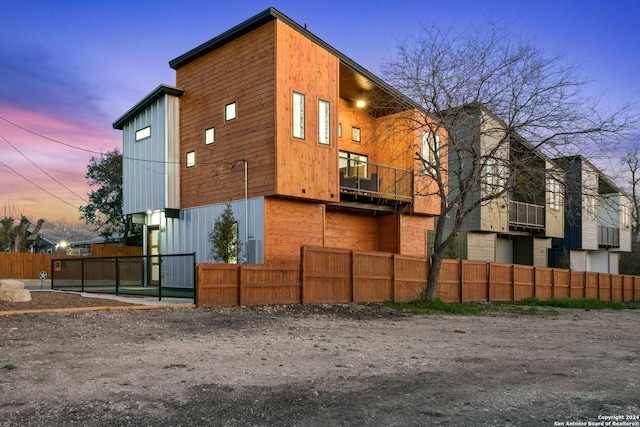 property exterior at dusk with a balcony