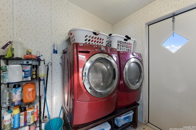 clothes washing area featuring a textured ceiling and washer and clothes dryer