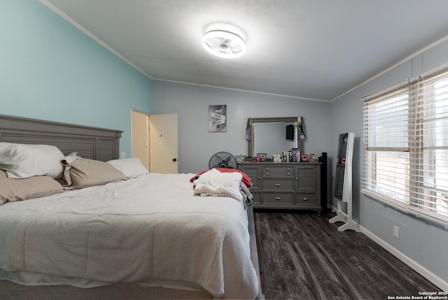 bedroom featuring dark hardwood / wood-style floors, crown molding, and vaulted ceiling