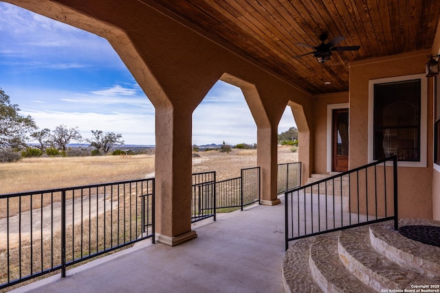 view of patio / terrace with ceiling fan and a rural view