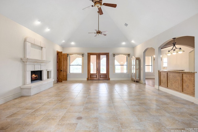 unfurnished living room with high vaulted ceiling, a wealth of natural light, and ceiling fan