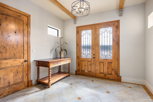 foyer entrance with french doors, a notable chandelier, and beamed ceiling