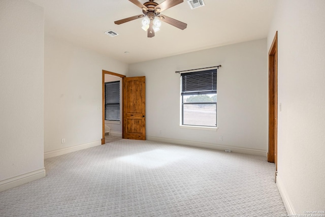 spare room with ceiling fan and light colored carpet