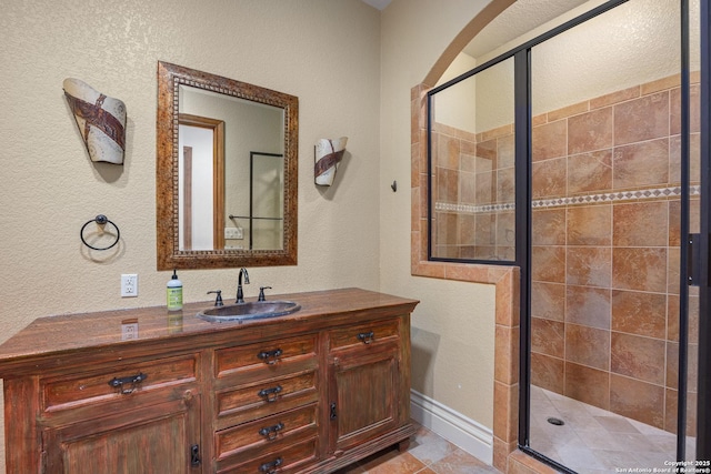 bathroom with vanity, a shower with shower door, and tile patterned flooring