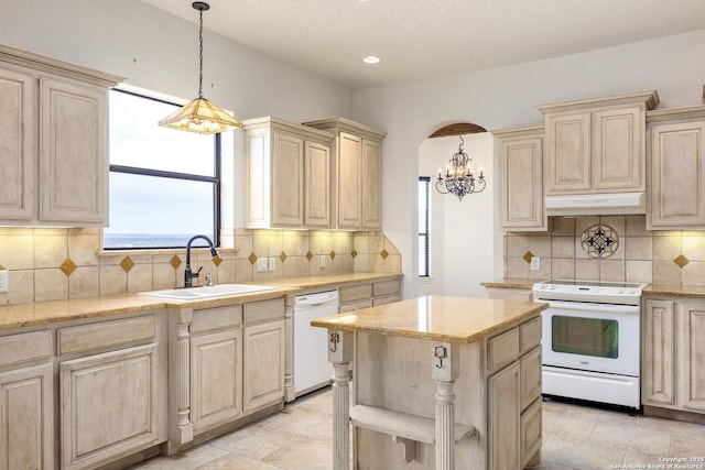 kitchen featuring sink, a kitchen island, white appliances, and a healthy amount of sunlight