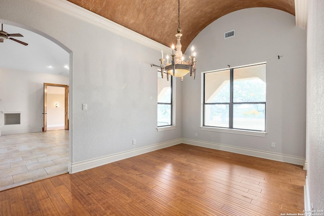 spare room featuring ceiling fan with notable chandelier, light hardwood / wood-style flooring, lofted ceiling, and ornamental molding