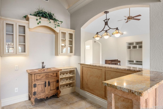 kitchen featuring sink, kitchen peninsula, pendant lighting, ceiling fan, and lofted ceiling