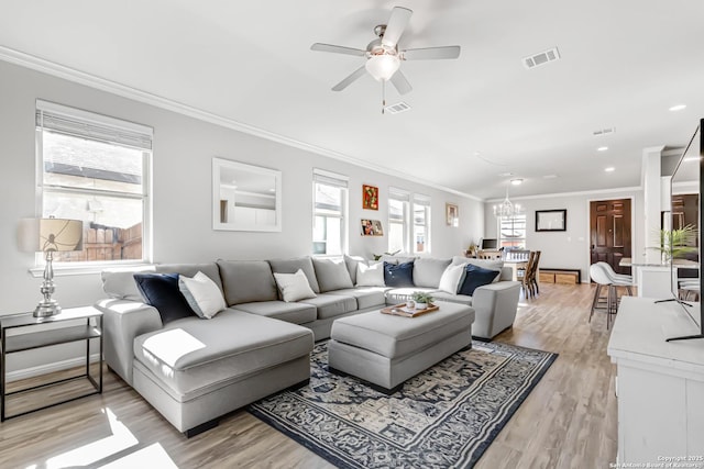 living room featuring ceiling fan with notable chandelier, ornamental molding, and light hardwood / wood-style floors