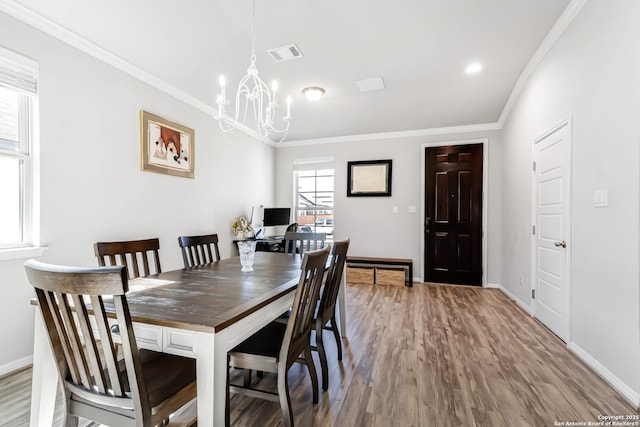 dining area featuring a notable chandelier, crown molding, and wood-type flooring