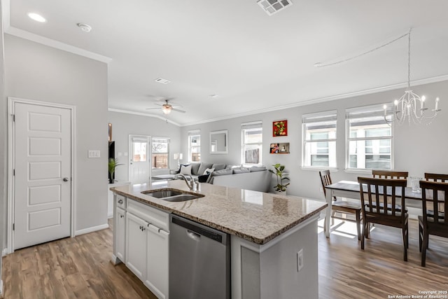 kitchen with a kitchen island with sink, stainless steel dishwasher, sink, white cabinets, and light stone counters