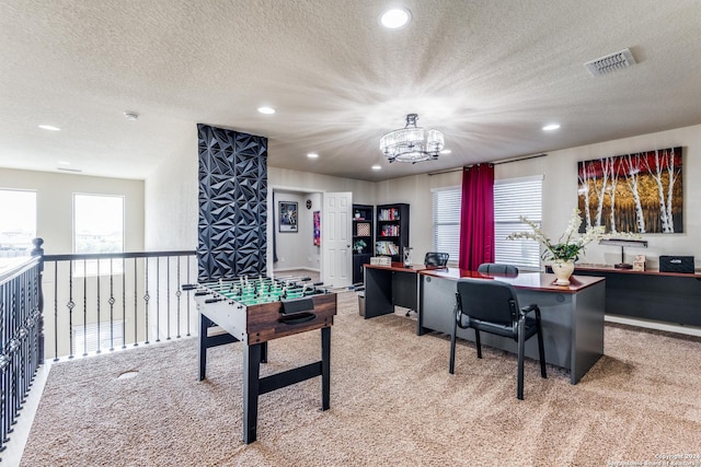 recreation room with a chandelier, light colored carpet, and a textured ceiling