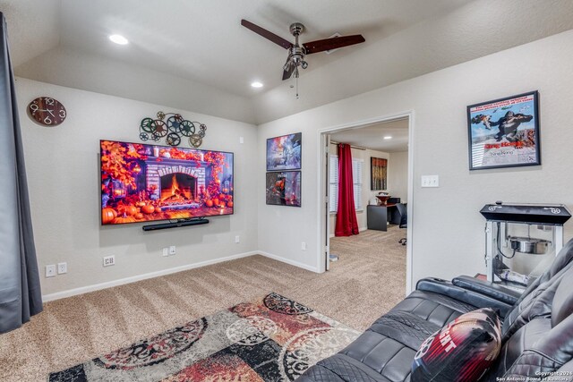 carpeted home theater room featuring ceiling fan and a brick fireplace