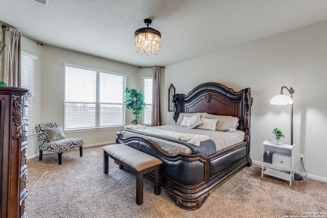 bedroom featuring carpet floors, multiple windows, and a chandelier