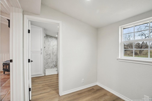 unfurnished bedroom featuring vaulted ceiling and light hardwood / wood-style floors