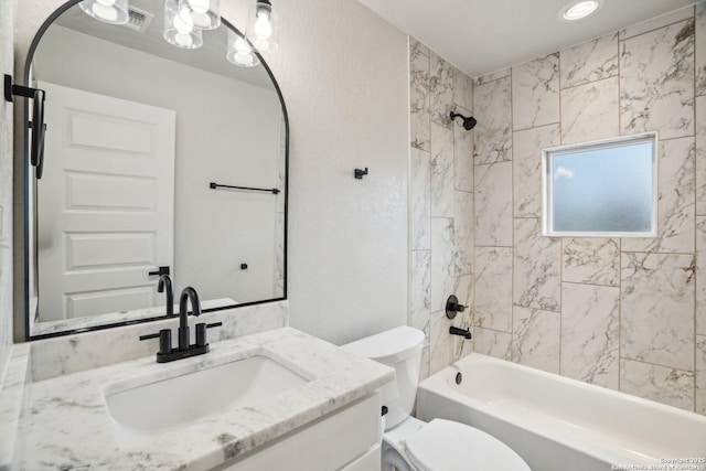 full bathroom featuring tiled shower / bath combo, vanity, and toilet