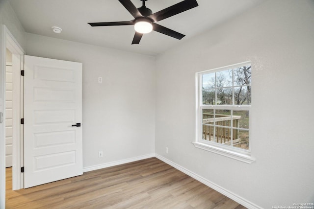 spare room with ceiling fan, plenty of natural light, and light wood-type flooring