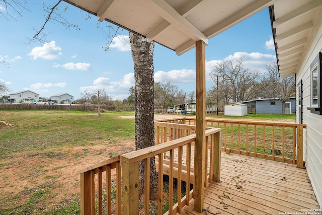 deck featuring a lawn and a storage unit