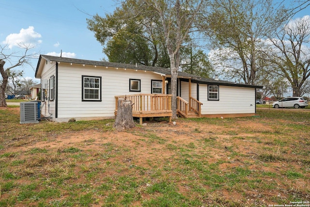 rear view of property with a wooden deck, a yard, and central AC