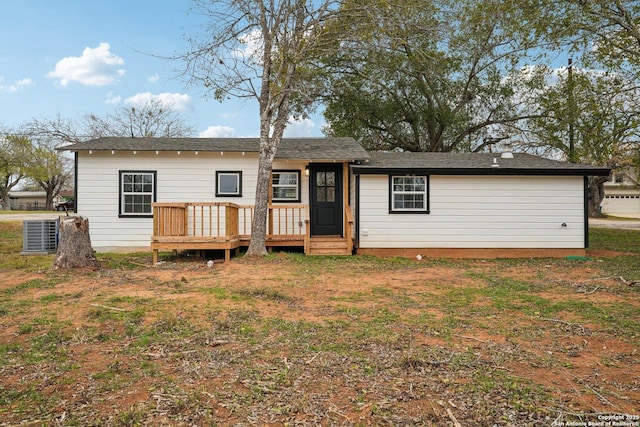 view of front of property with a wooden deck, cooling unit, and a front lawn