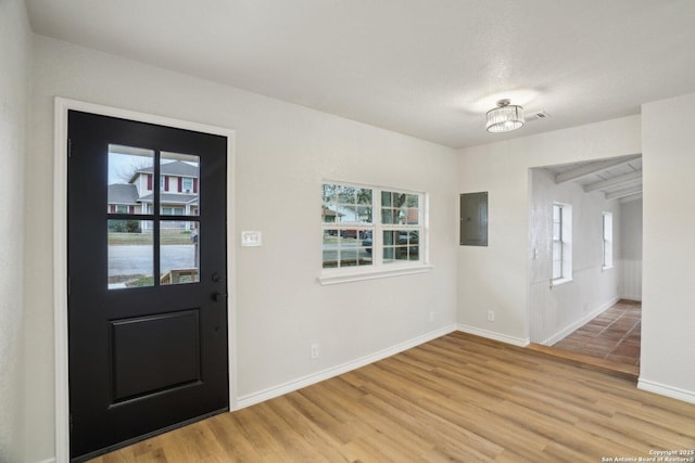 foyer entrance with wood-type flooring and electric panel