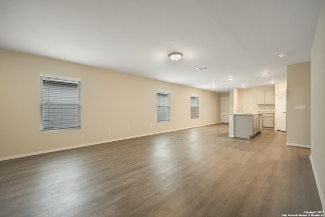 unfurnished living room featuring light hardwood / wood-style floors and sink