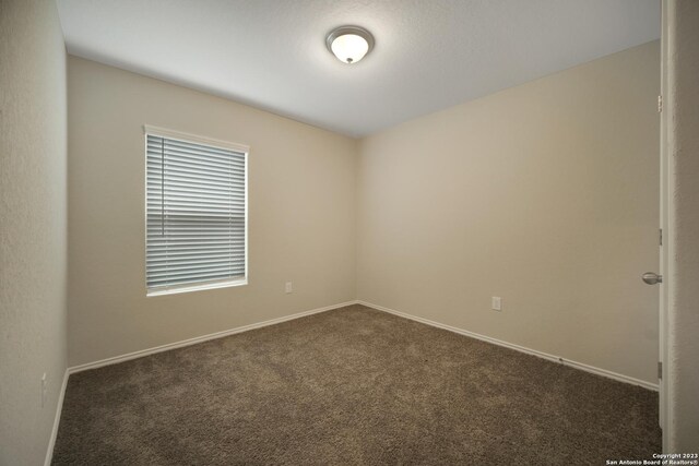 empty room featuring dark colored carpet