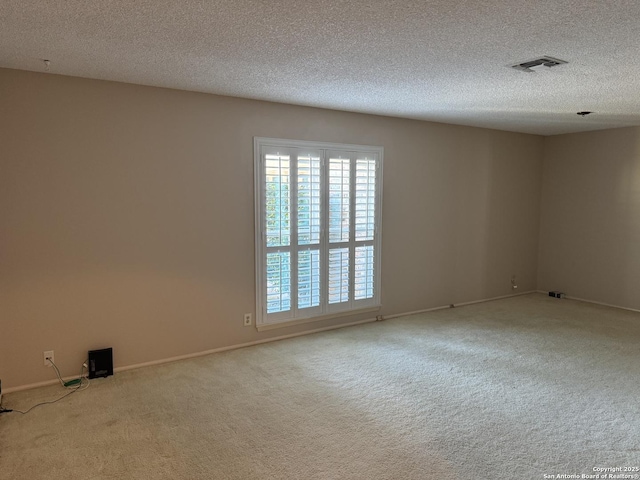 carpeted empty room with a textured ceiling