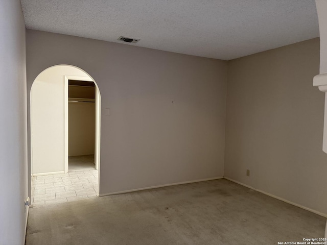 carpeted spare room with a textured ceiling