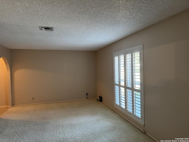 carpeted spare room with a textured ceiling