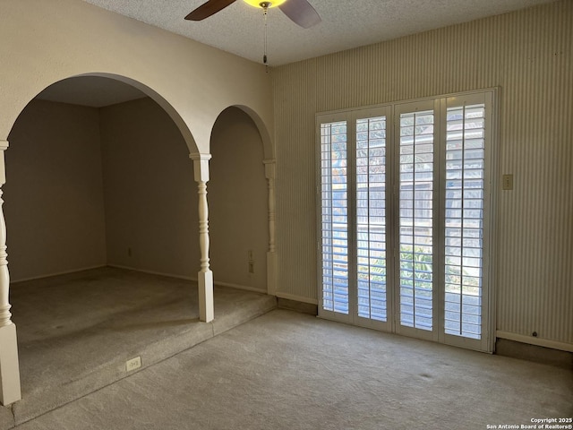 unfurnished room featuring a textured ceiling, carpet flooring, and ceiling fan