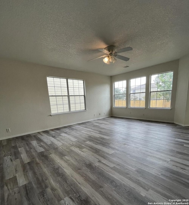 empty room featuring ceiling fan, dark hardwood / wood-style floors, and a textured ceiling