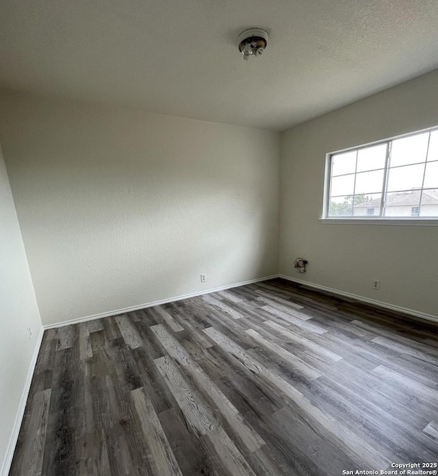 empty room with dark hardwood / wood-style flooring