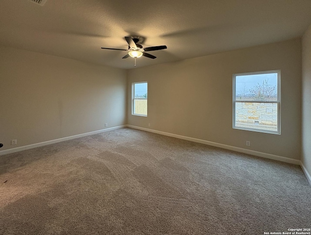 unfurnished room with ceiling fan and carpet